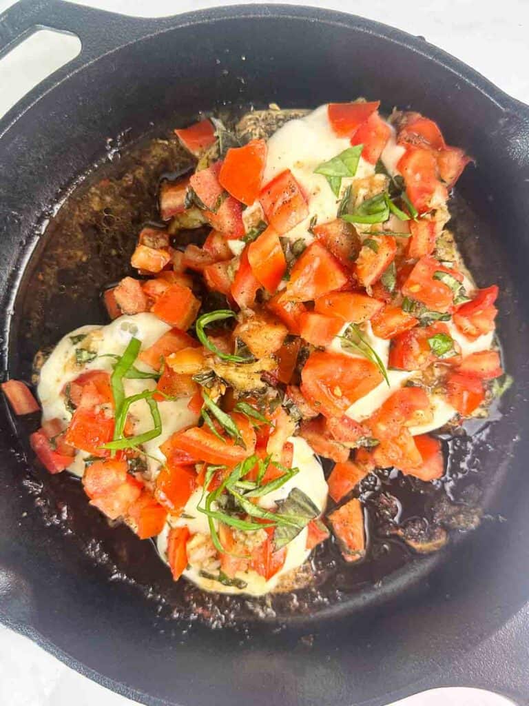 Grilled bruschetta chicken in a cast iron skillet.