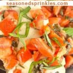 Grilled bruschetta chicken in a skillet. Text reads: grilled chicken bruschetta, seasonedsprinkles.com