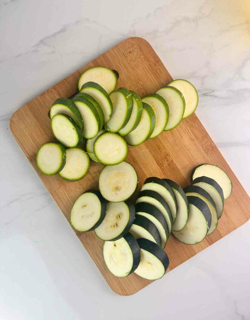 Zucchini rounds on a wood cutting board.