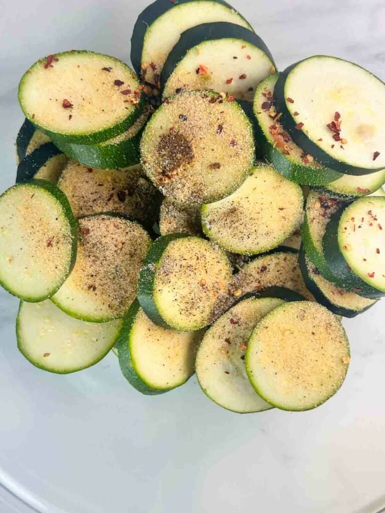 Seasoning on top of zucchini rounds.