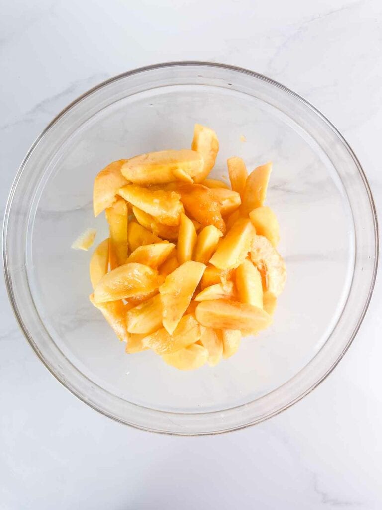 Peaches in a bowl, ready to mix with other peach cobbler filling ingredients.