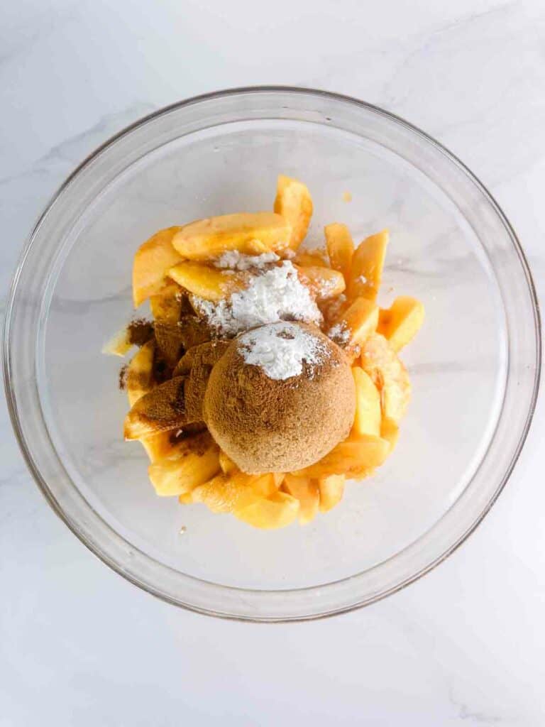 Ingredients ready to mix together for peach cobbler filling.