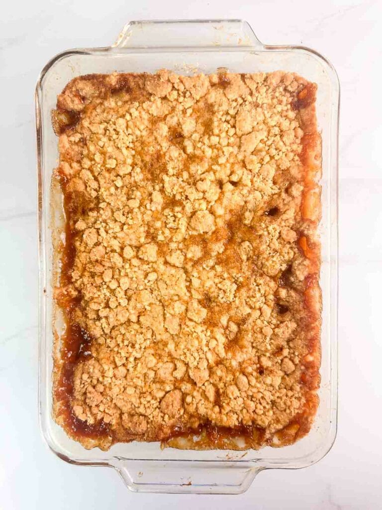 Baking dish of peach cobbler with cake mix ready to serve.