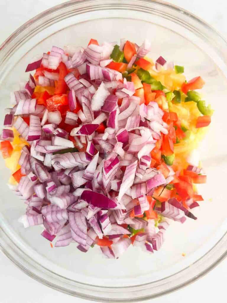 Ingredients for peach salsa in a mixing bowl to mix together.