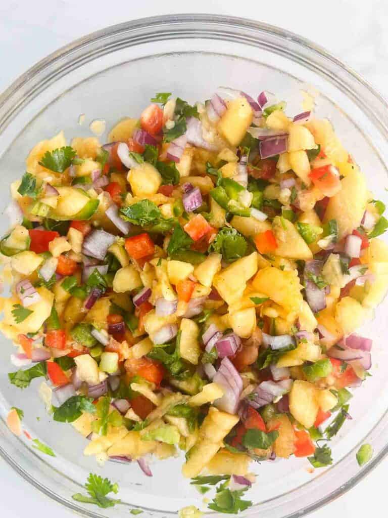 Peach salsa mixed together in a bowl.