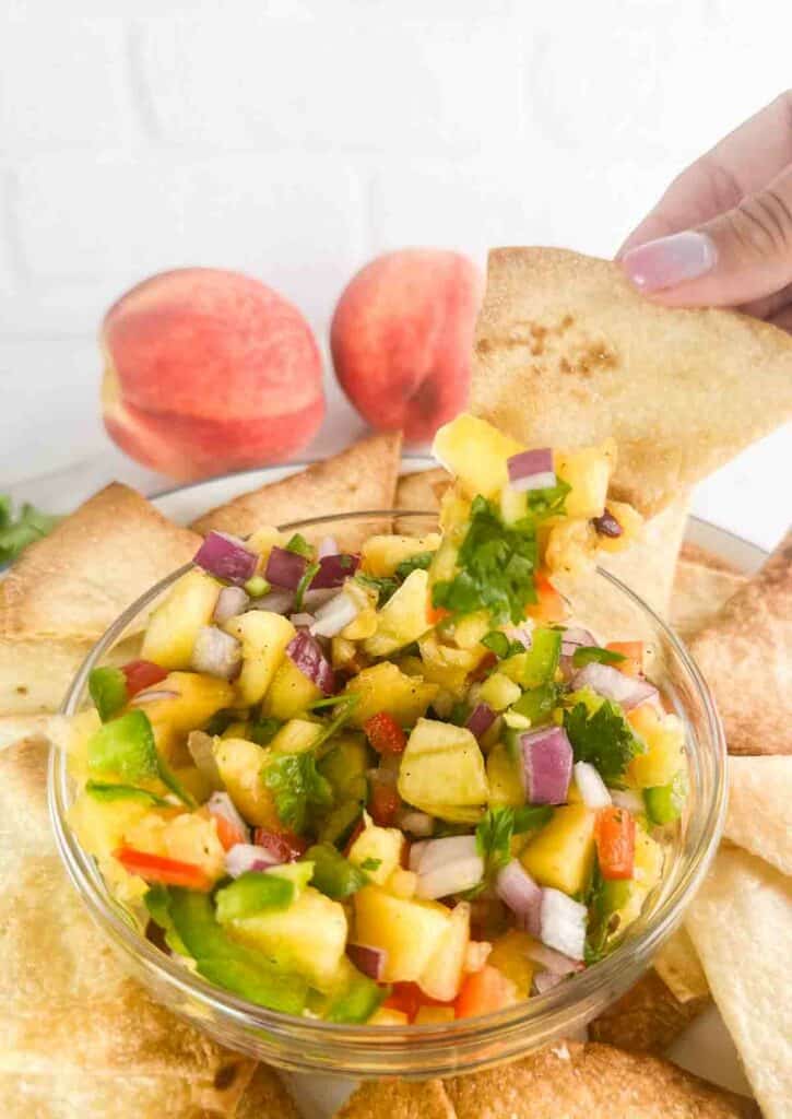 Eating peach salsa with homemade tortilla chip.