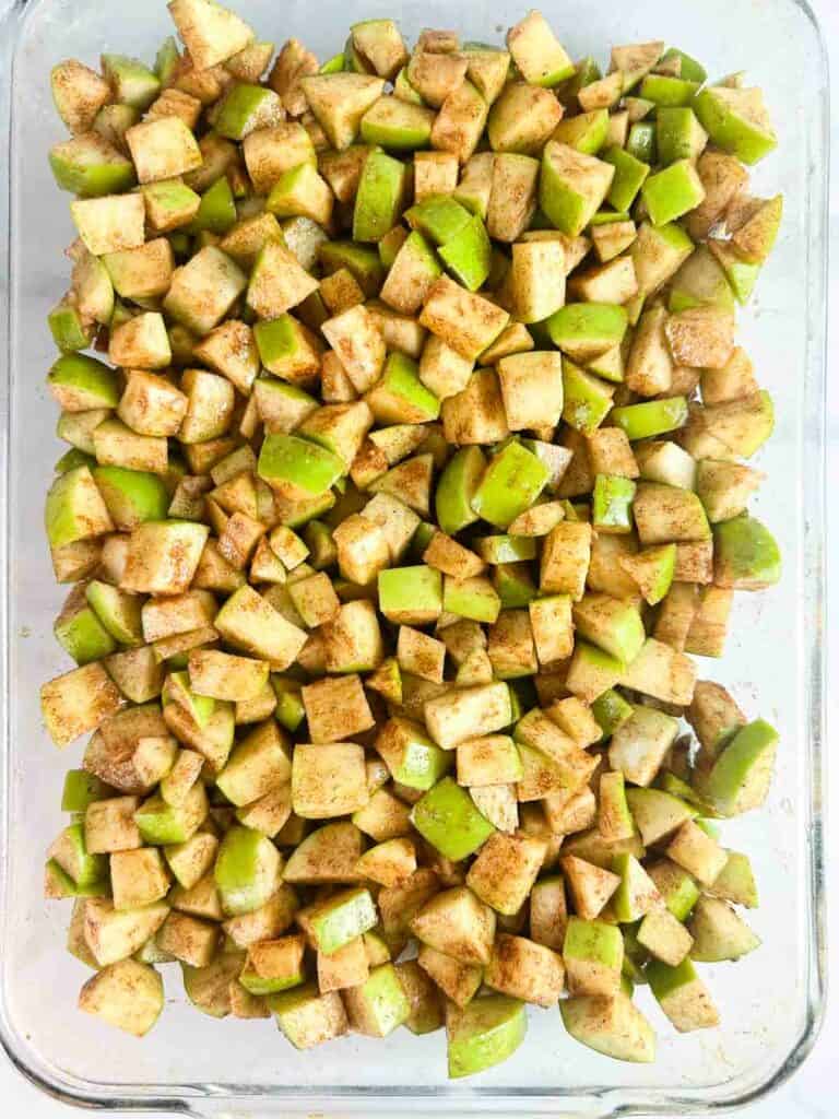 Apple pieces spread in a baking dish ready to top.