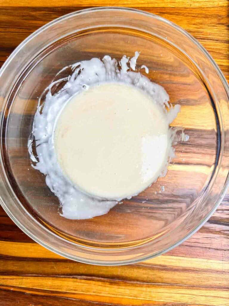 Icing for chai cookies in a small clear bowl.