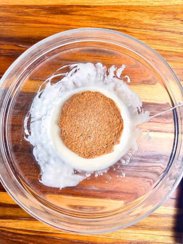 Dipping chai cookies in a bowl of icing.