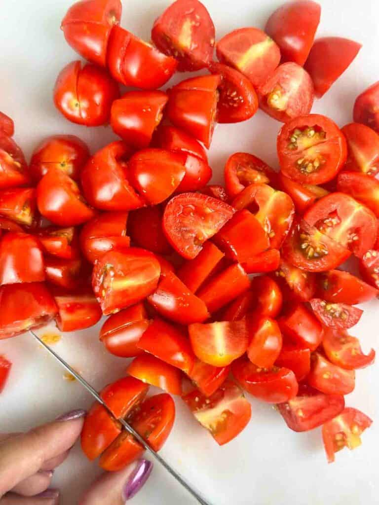 Slicing tomatoes into quarters.