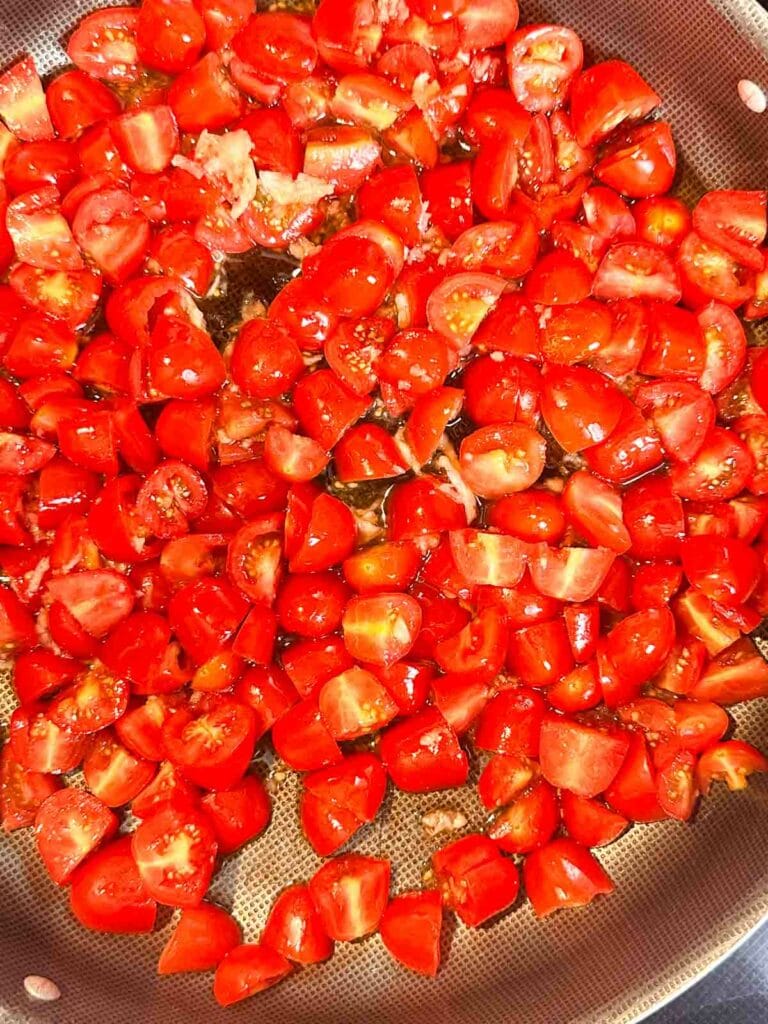 Tomatoes in a skillet with olive oil.