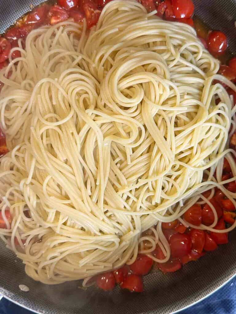 Pasta with tomatoes in a skillet.