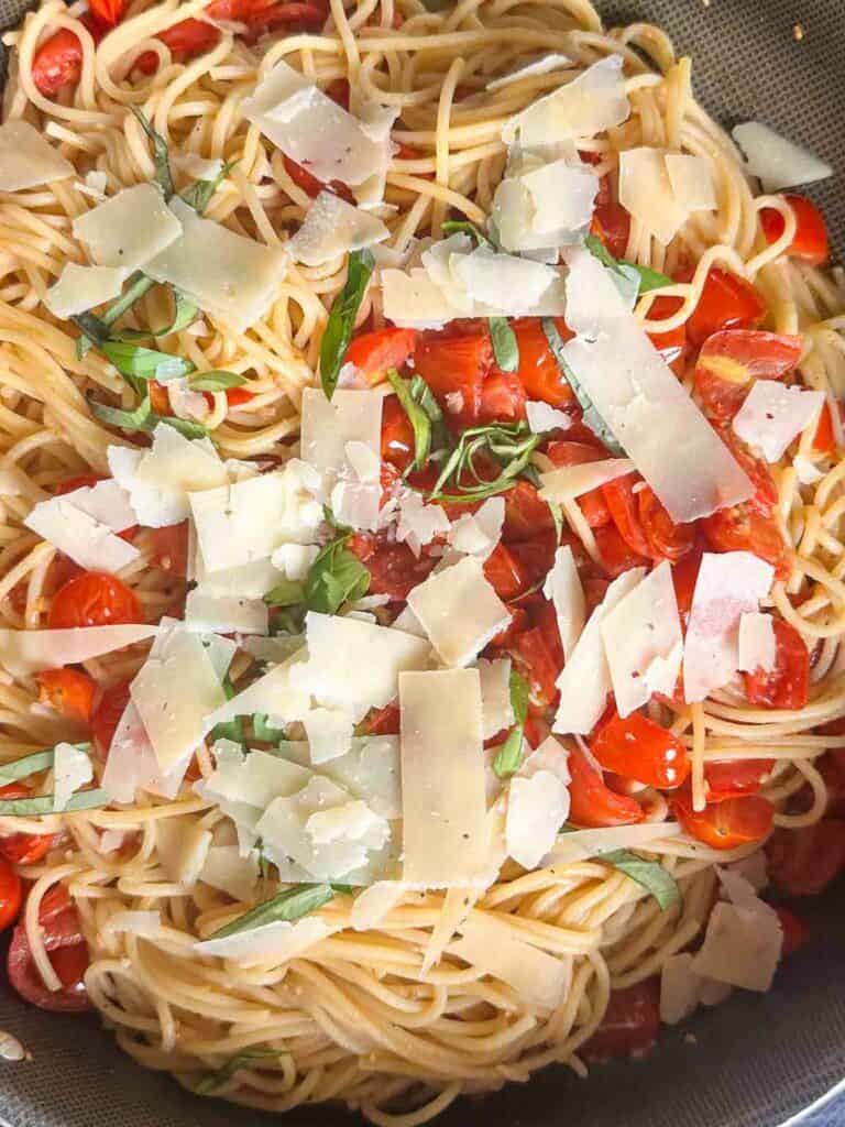 Cherry tomato pasta with basil and parmesan cheese in the skillet.