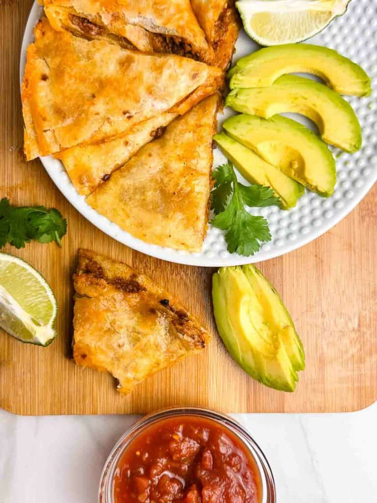 Chicken quesadillas with salsa, limes, and avocado.