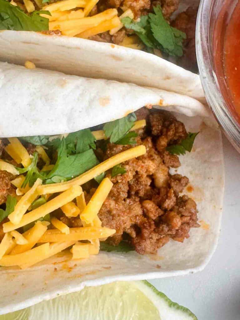 Ground chicken taco meat tacos with cheese and salsa.