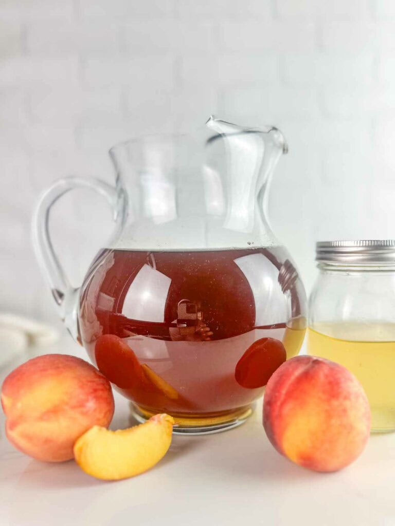 Ingredients for homemade peach tea recipe: brewed tea, peaches, and peach simple syrup.