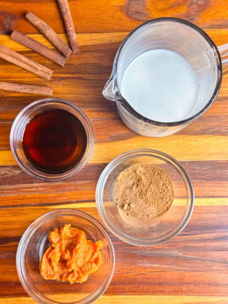 Homemade Pumkin Spice coffee creamer recipe ingredients: half and half, maple syrup, pumpkin puree, cinnamon, and pumpkin spice blend.