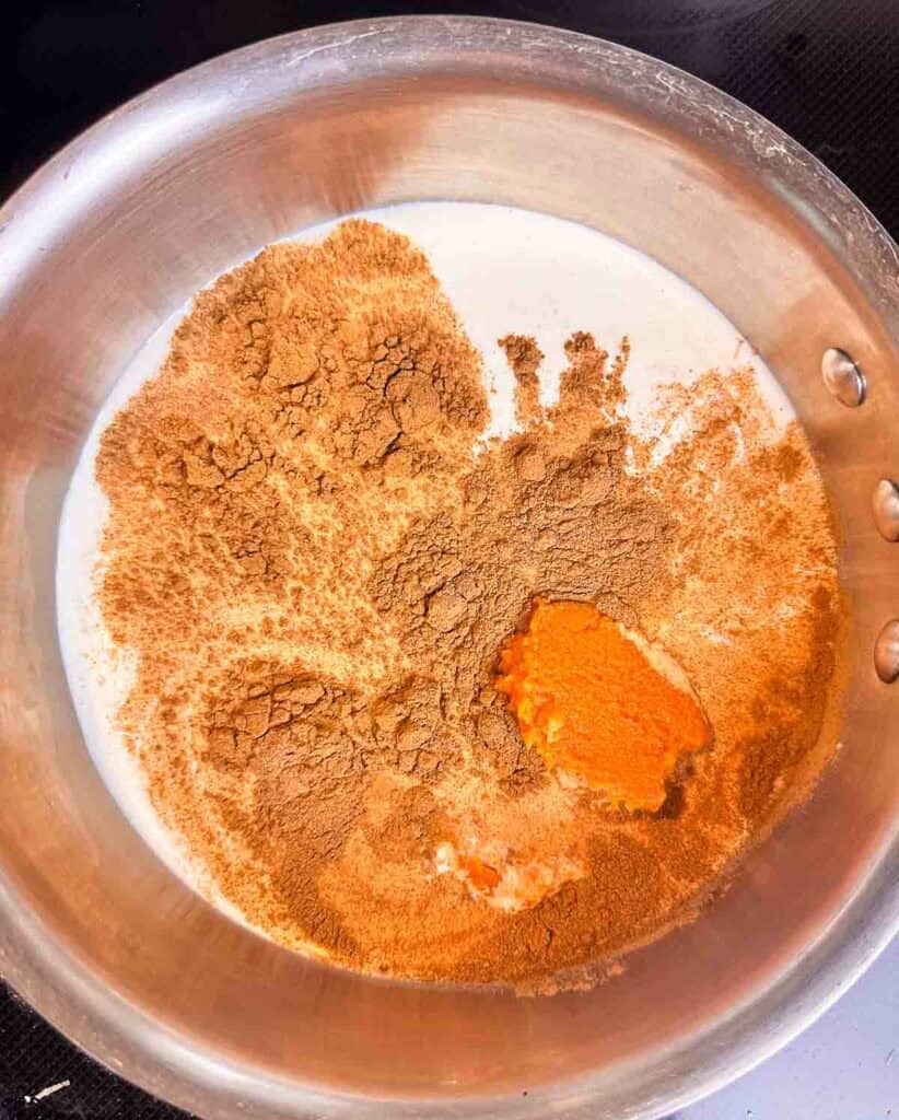 Half and half, spices, and pumpkin puree in a stainless steal bowl.