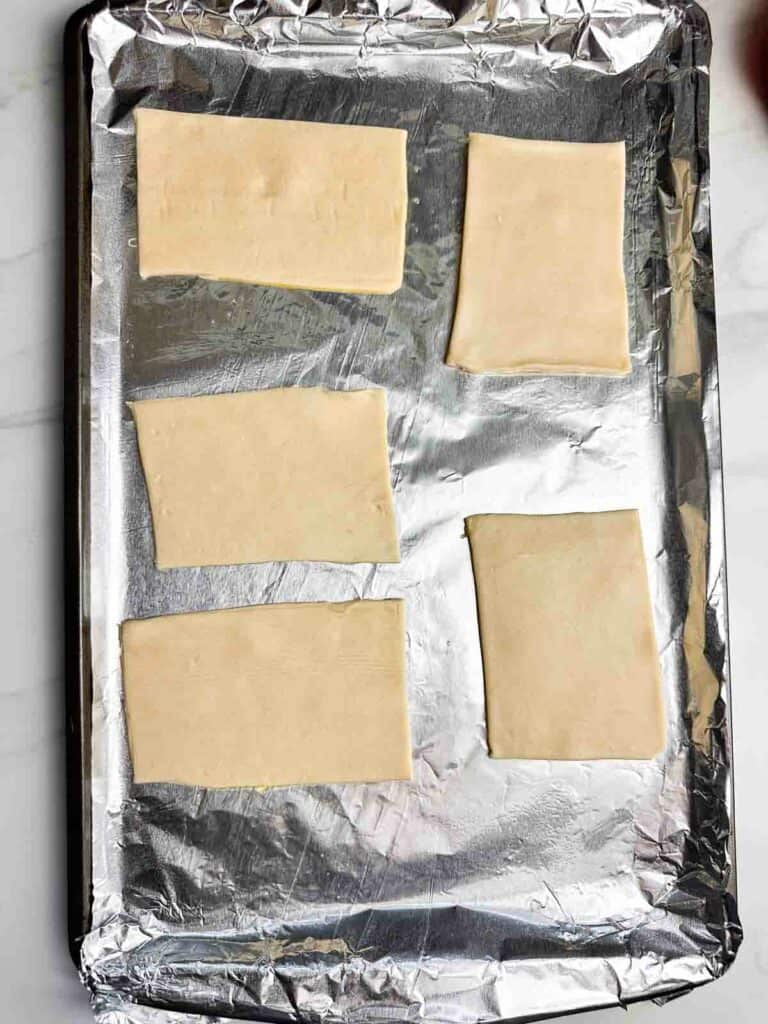 5 rectangles of pie crust on a baking sheet