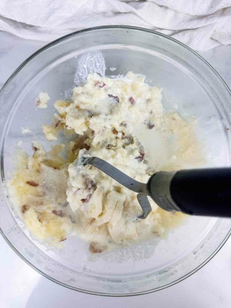 Cream and potatoes getting mashed.
