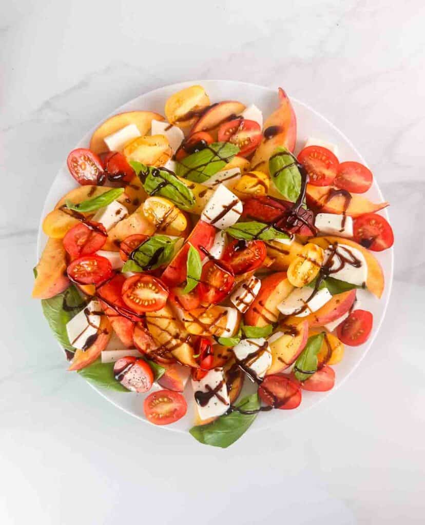 A drizzle of balsamic over a peach caprese salad.