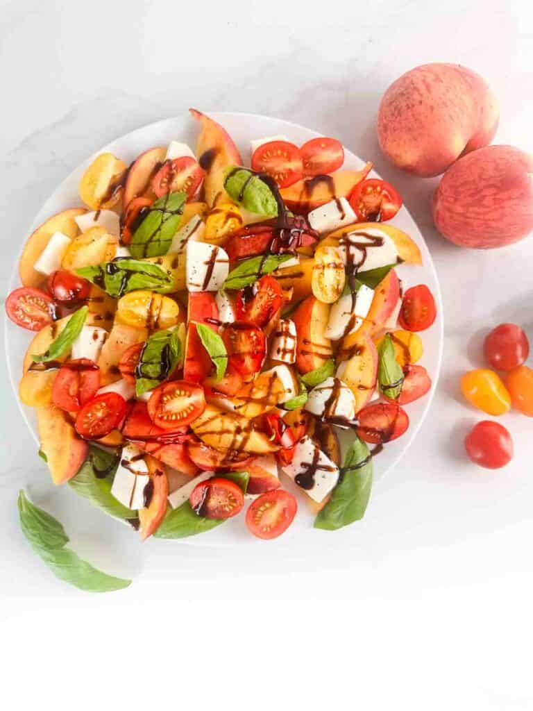 A drizzle of balsamic over a peach caprese salad.