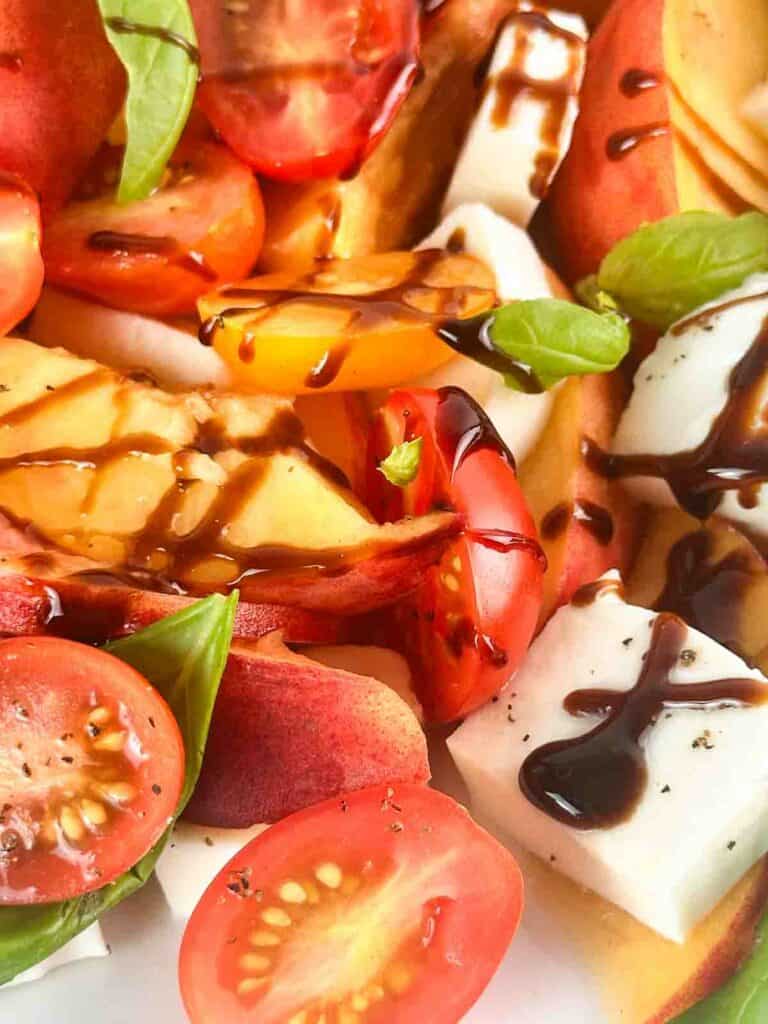 A drizzle of balsamic over a peach caprese salad.