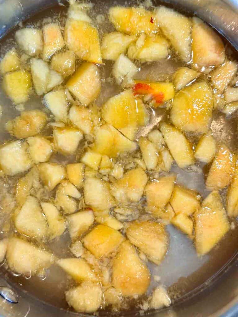 Adding peaches to simple syrup.