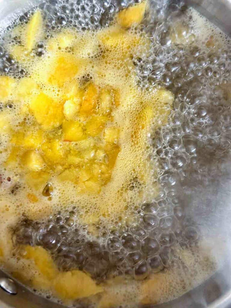 Simmering peaches to make a simple syrup.