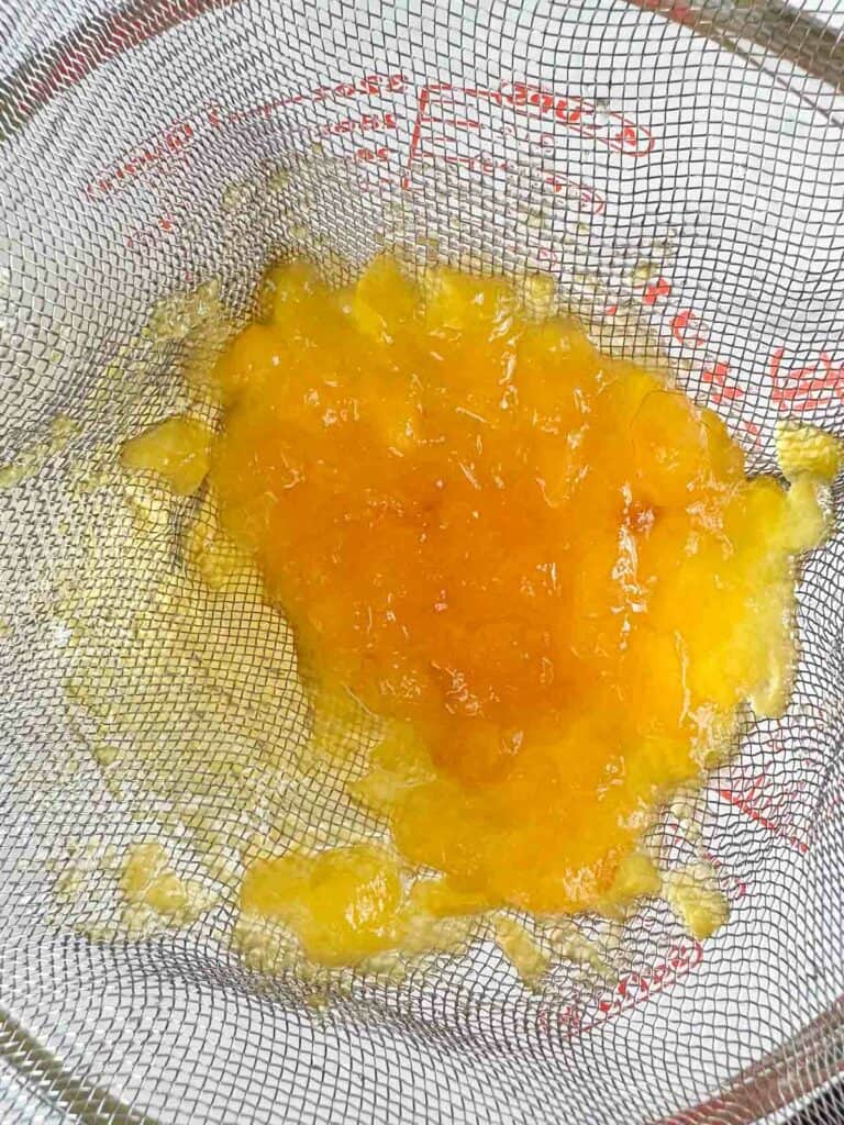 Strain peaches out of the simple syrup.