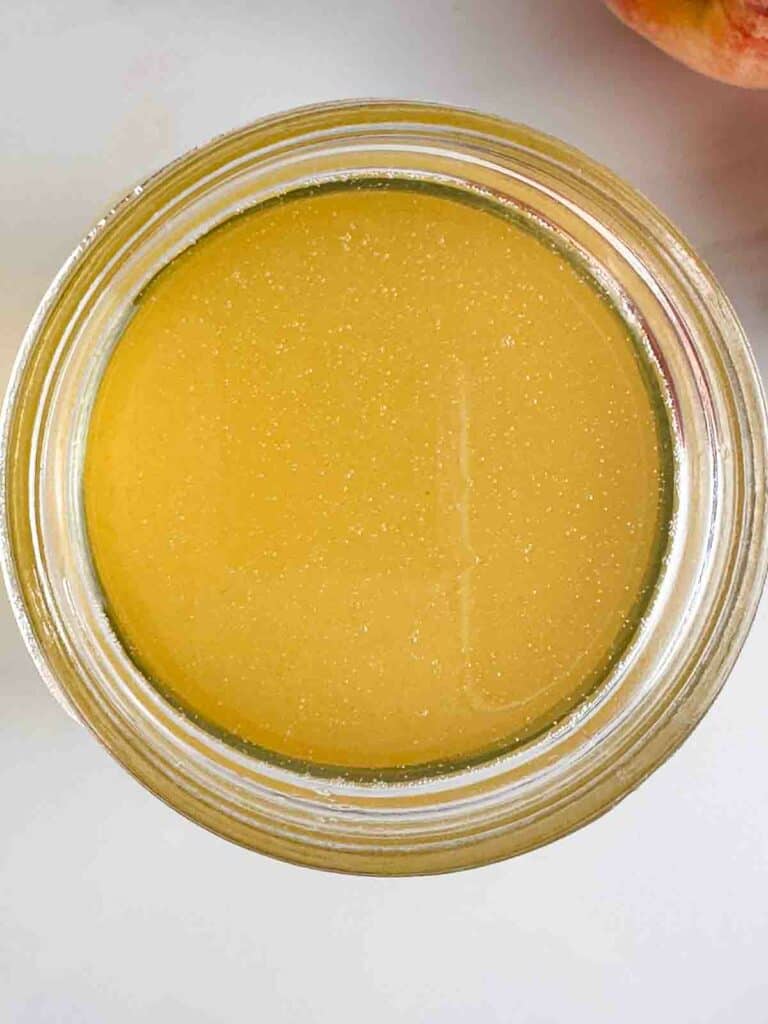 Peach simple syrup in a mason jar.