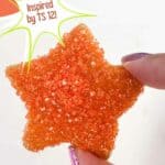 Star sugar cookie covered in orange glitter sprinkles. Text reads: star sugar cookies, inspired by TS 12! www.seasonedsprinkles.com