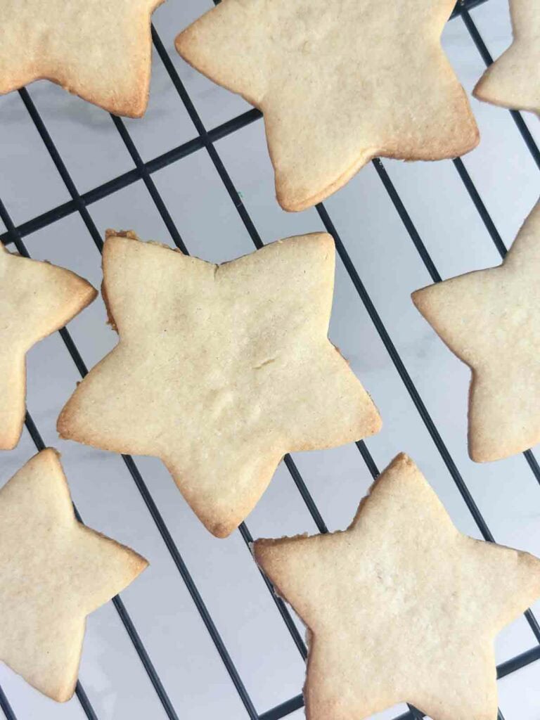 Star shaped cookies cooling on a cooling rack.