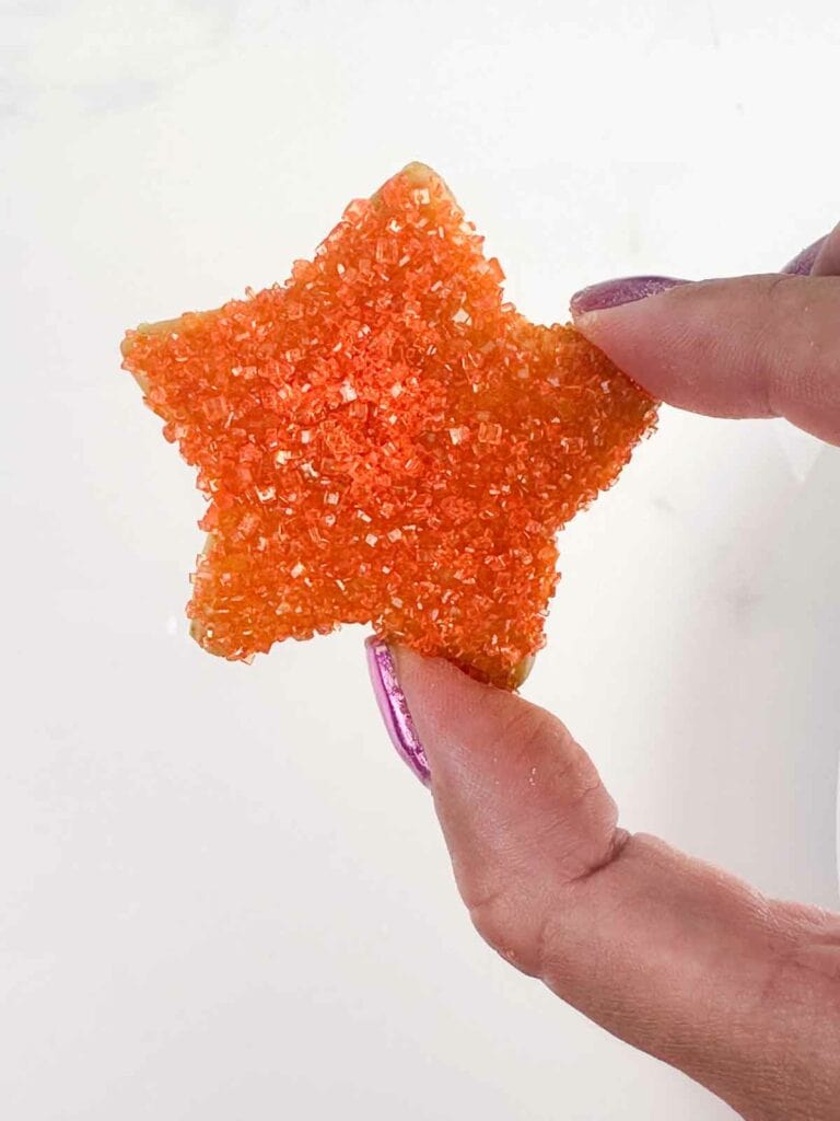 Star sugar cookie with orange glitter sprinkles.