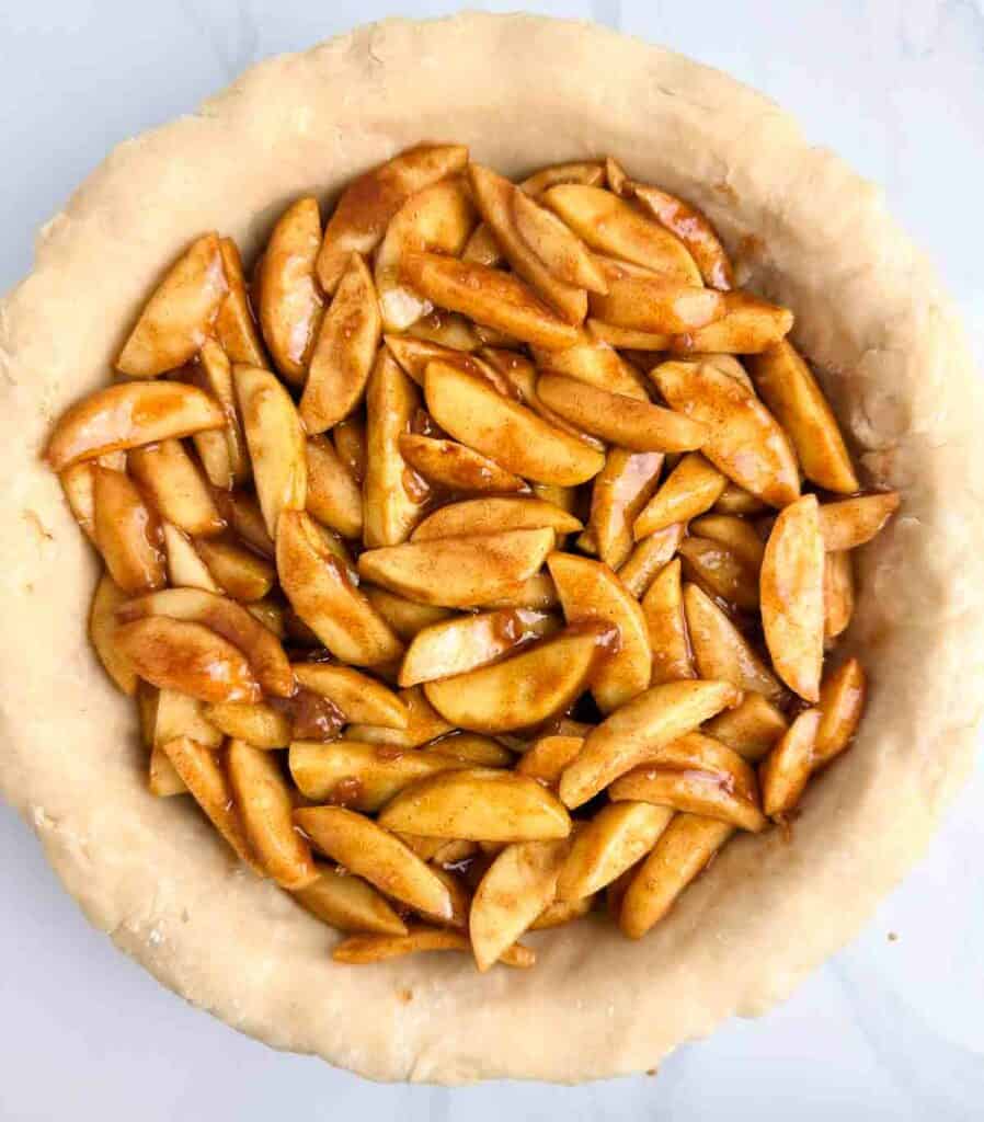 Apple pie filling in an uncooked pie crust.