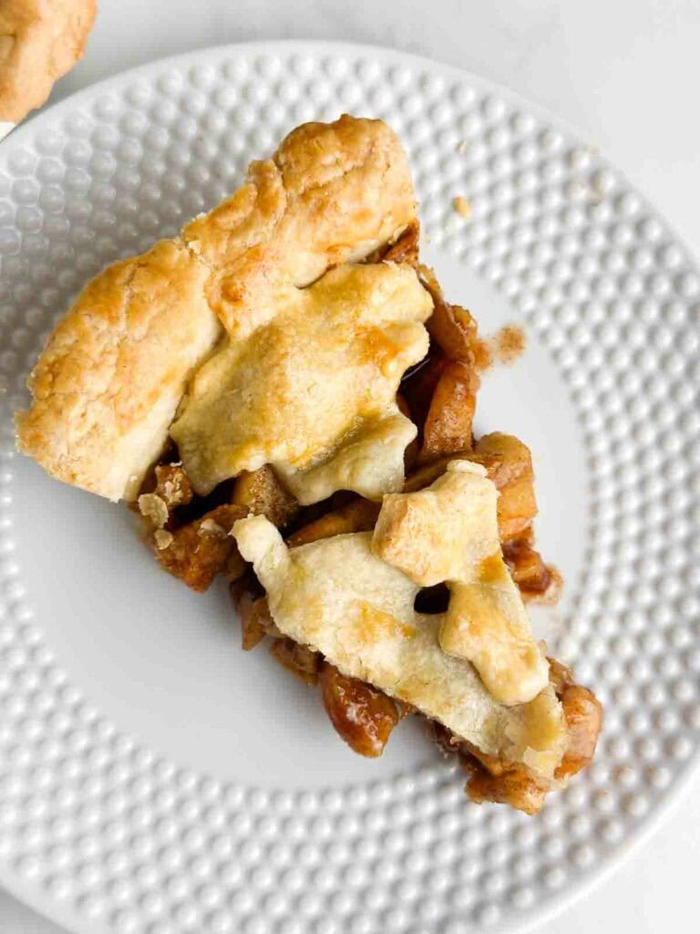 Homemade apple pie on a white plate.