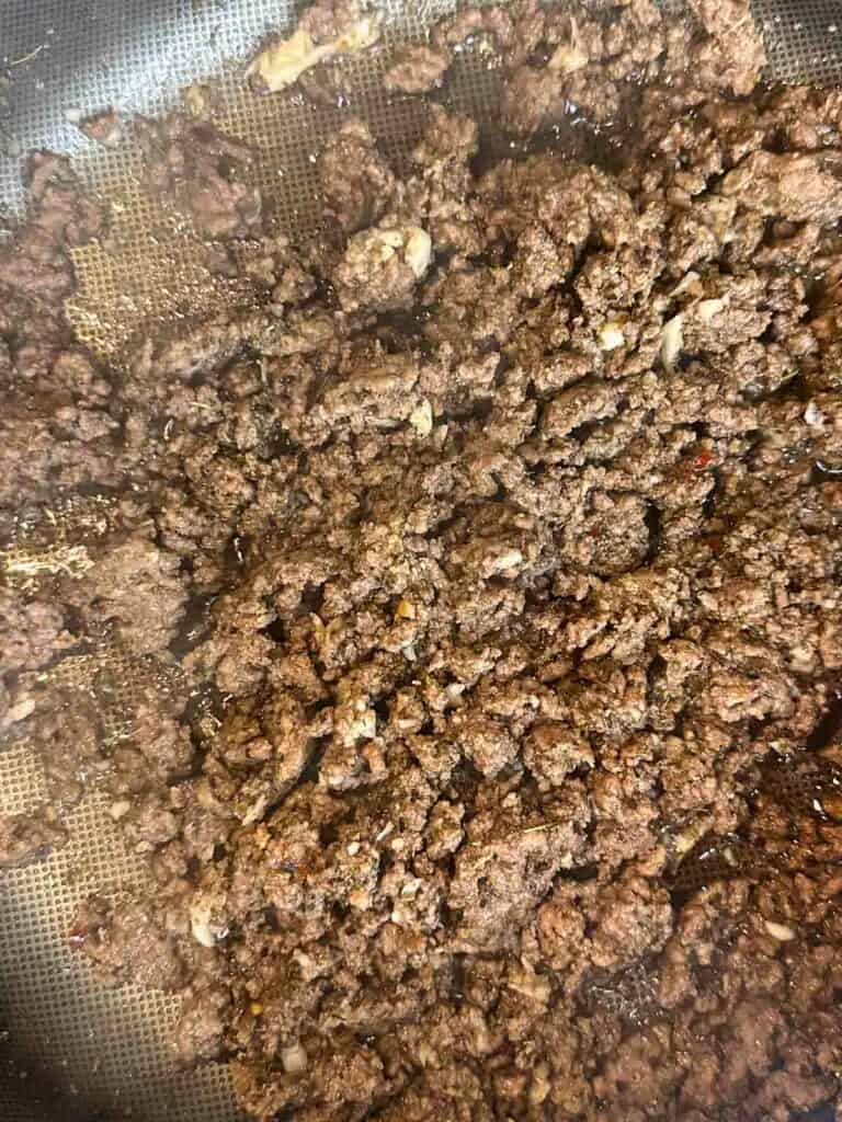 Beef browning in a pan.