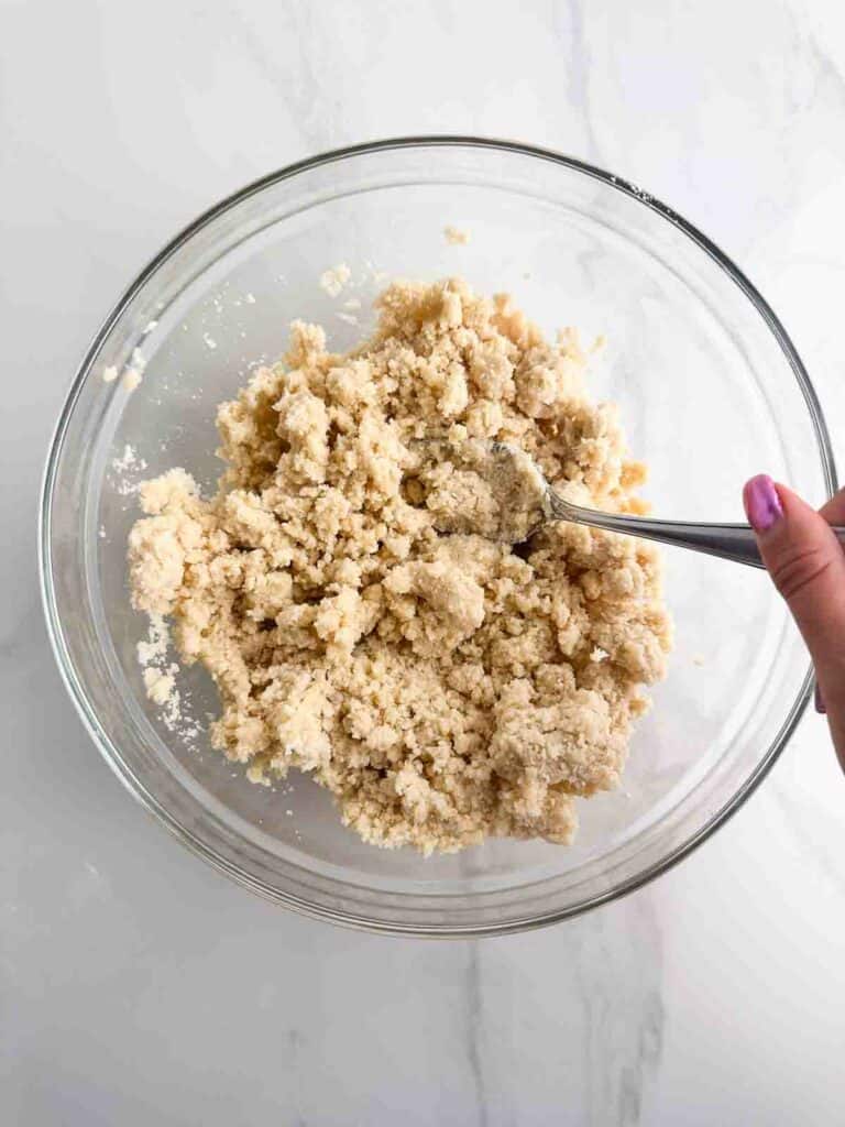 Mixing water into pie crust dough with a spoon.