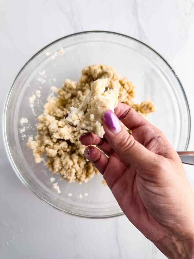 Testing pie crust dough to see if it is ready to form into balls and chill.