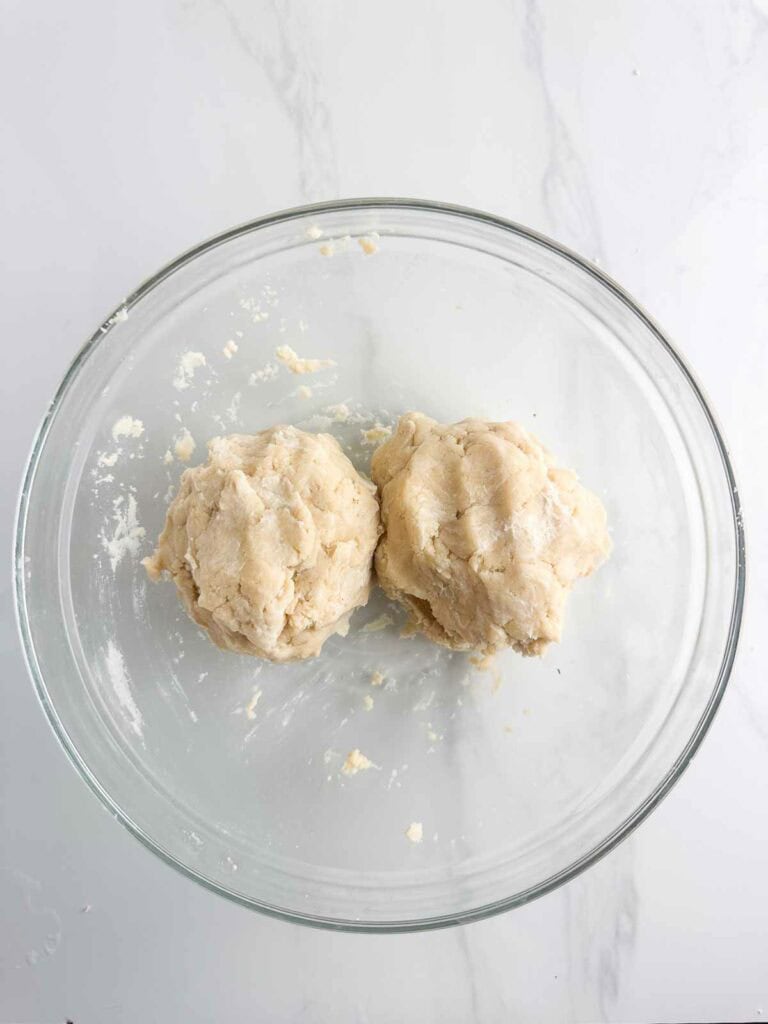 Pie crust dough split into two roughly even balls.