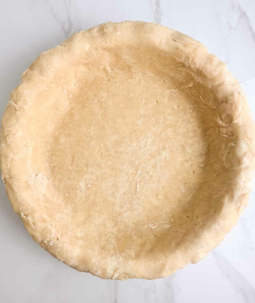 Pie crust rolled out and pushed into a pie baking dish.