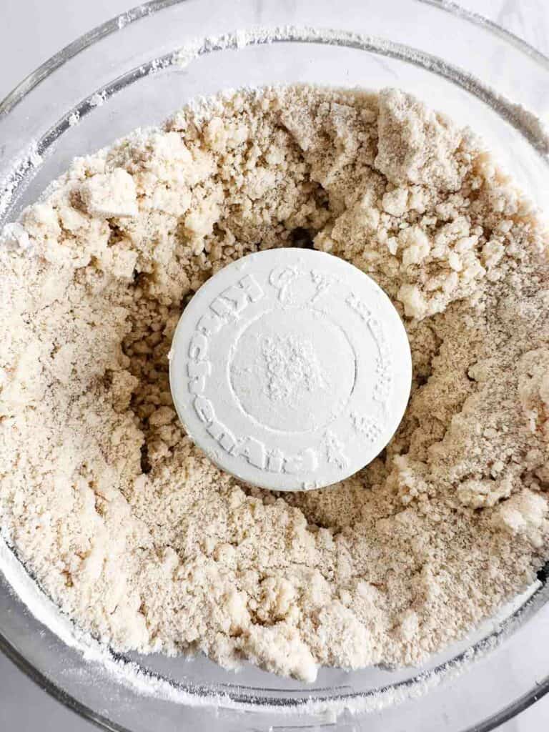 Pie crust dough with flour and butter mixed together in a food processor.