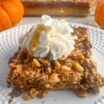 A casserole dish full of pumpkin praline cake with a whipped cream topped slice on a plate