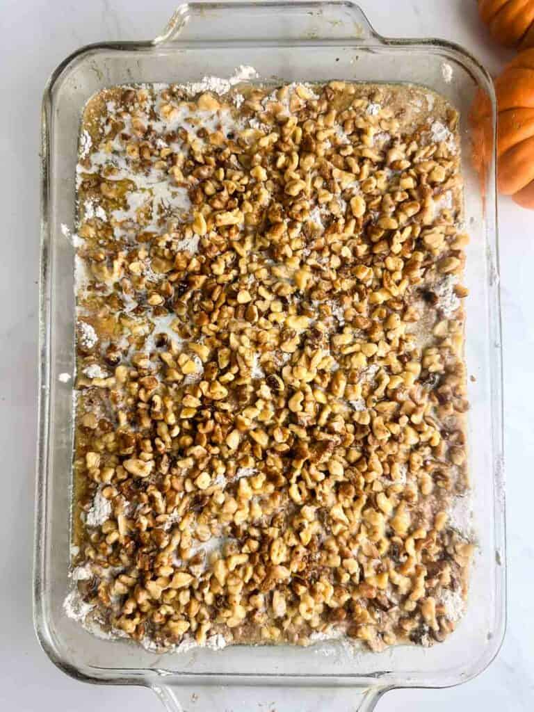 Top the cake mix layer of the pumpkin praline cake with walnuts or pecans and melted butter