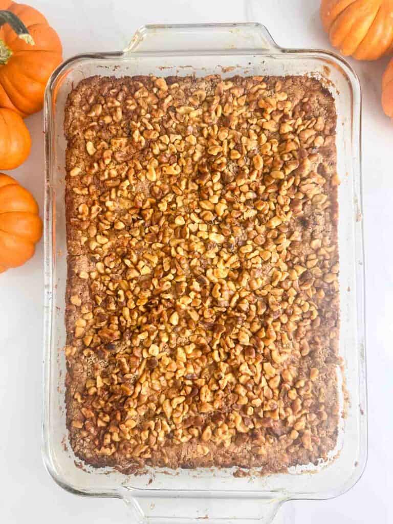 Pumpkin Praline Cake out of the oven surrounded by decorative pumpkins