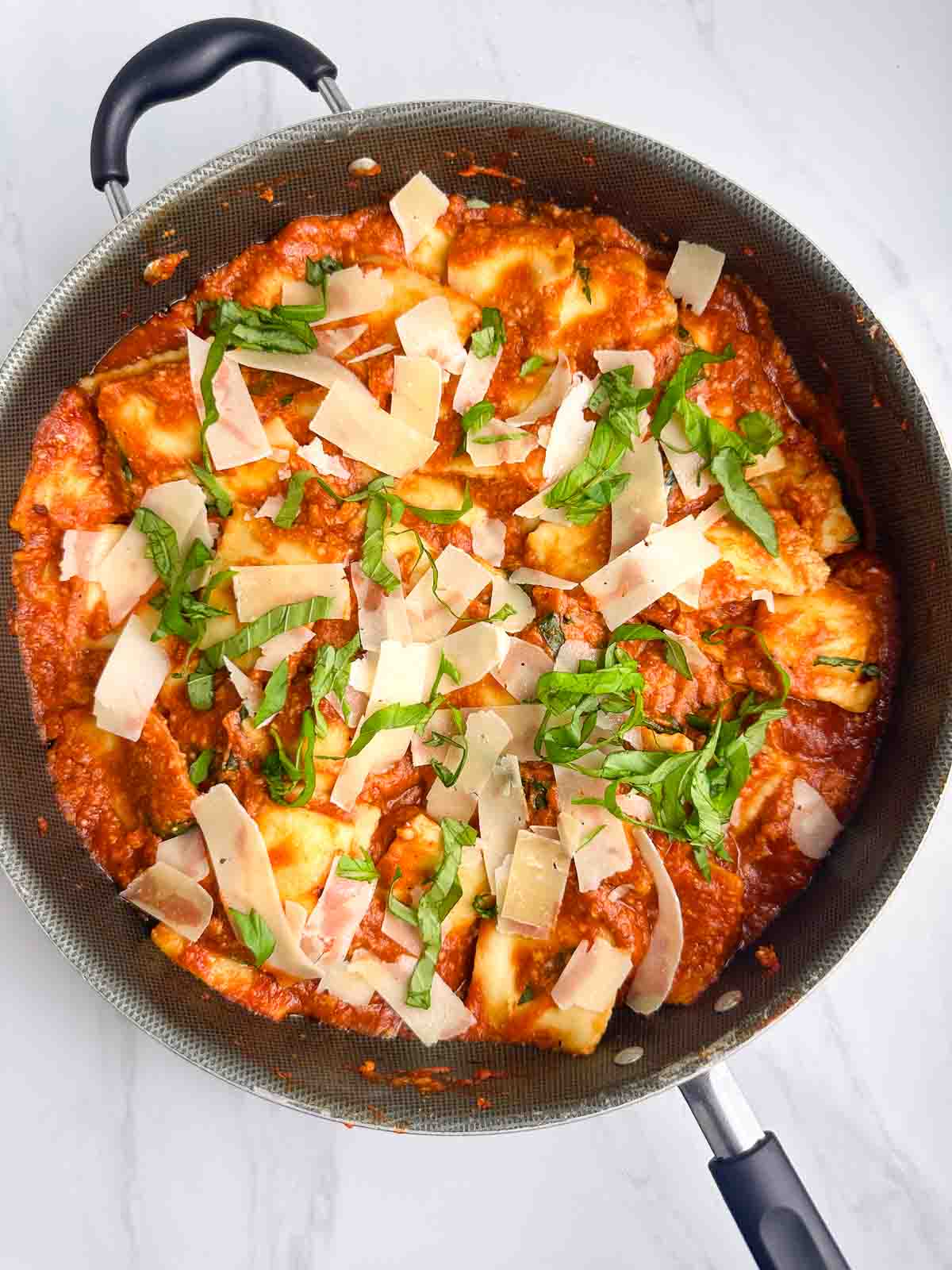 a skillet full of ravioli with sauce