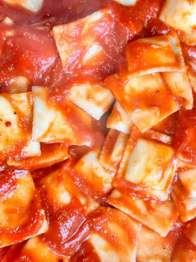 a skillet full of ravioli with sauce