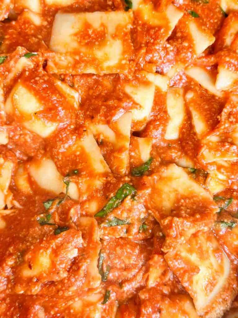 a skillet full of ravioli with sauce