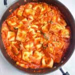 a skillet full of ravioli with sauce