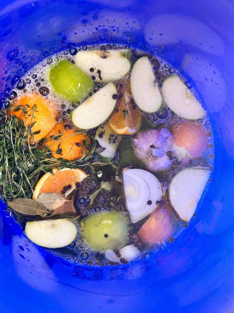 Fillng a bucket with ingredients for apple cider turkey brine.